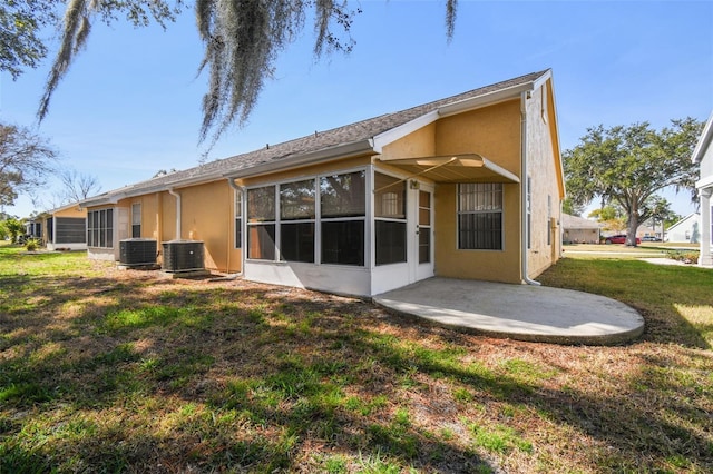 rear view of house featuring cooling unit, a yard, a sunroom, and a patio area