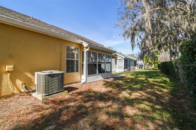 view of yard with central AC unit and a sunroom