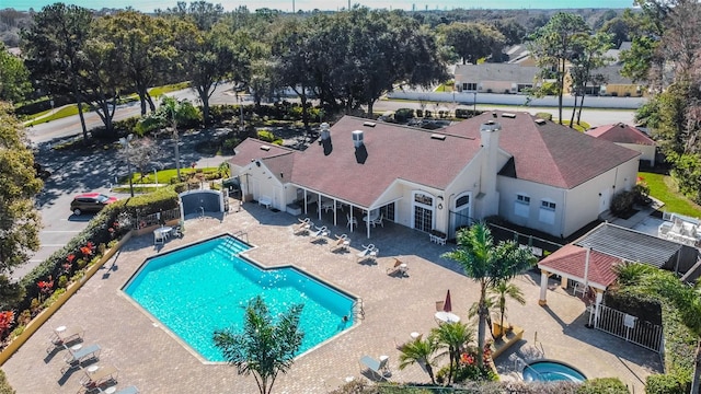 community pool with a community hot tub, a patio area, and fence