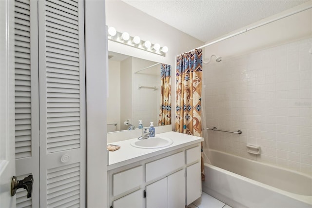 bathroom featuring vanity, shower / bath combo with shower curtain, a closet, a textured ceiling, and tile patterned floors