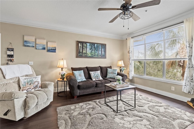 living room with a ceiling fan, crown molding, baseboards, and wood finished floors