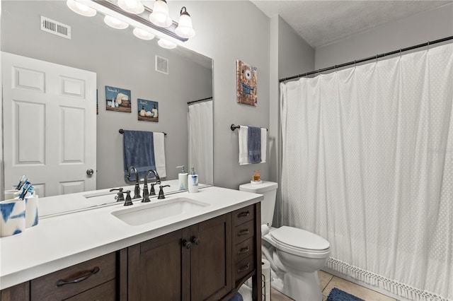 full bathroom featuring toilet, vanity, visible vents, and tile patterned floors