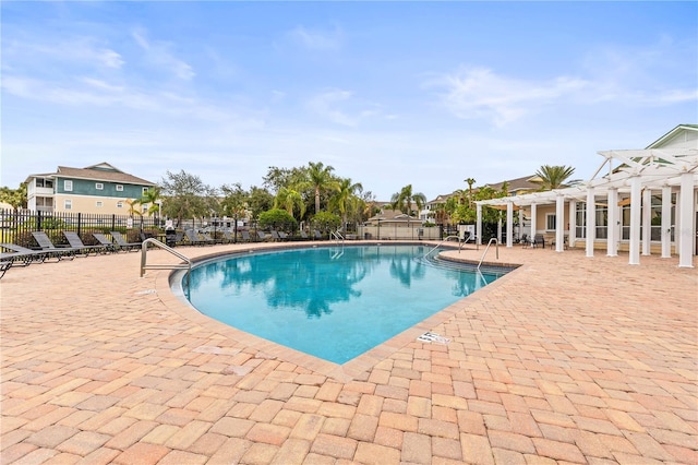 pool featuring a patio, fence, and a pergola