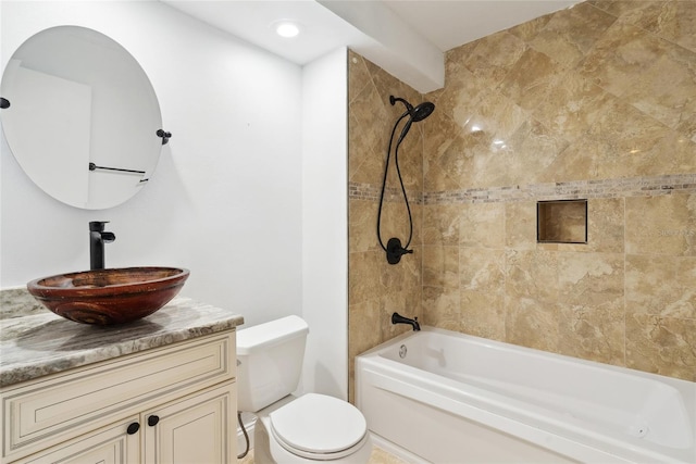 full bathroom featuring vanity, tiled shower / bath combo, and toilet