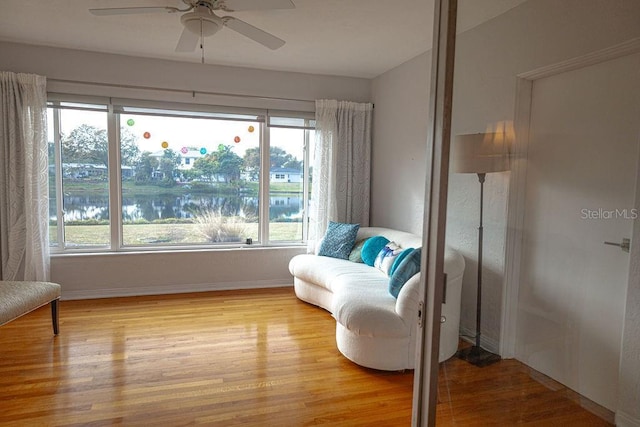 living area featuring light hardwood / wood-style floors and ceiling fan