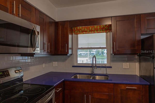 kitchen featuring appliances with stainless steel finishes, sink, and decorative backsplash