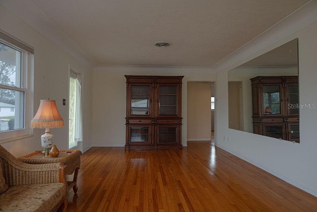 unfurnished room with wood-type flooring and ornamental molding