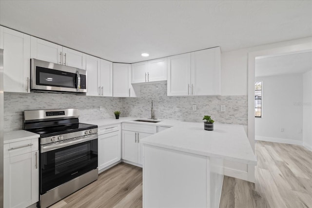 kitchen featuring white cabinetry, stainless steel appliances, and kitchen peninsula