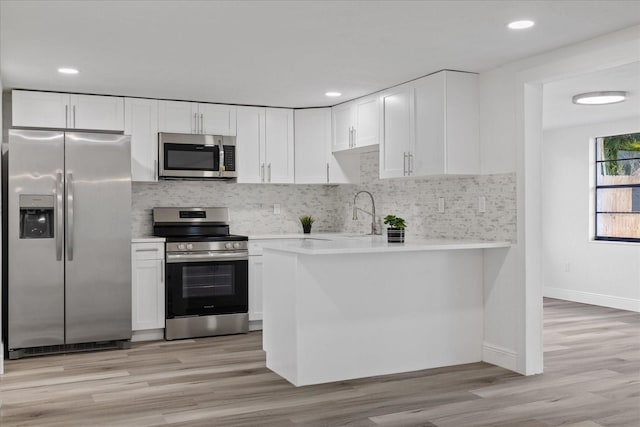 kitchen with decorative backsplash, stainless steel appliances, and white cabinets