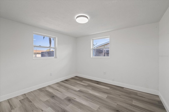 empty room featuring light hardwood / wood-style flooring and a textured ceiling