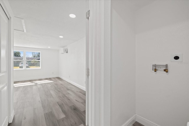 interior space featuring a wall mounted AC and light wood-type flooring