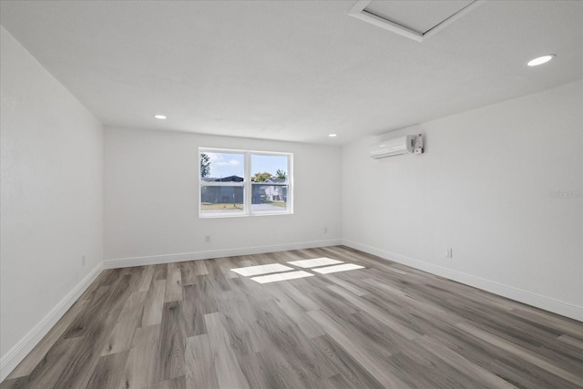 empty room featuring a wall mounted air conditioner and wood-type flooring