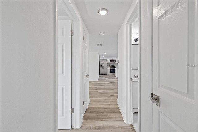 corridor with light hardwood / wood-style flooring