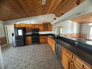 kitchen with sink, wood ceiling, vaulted ceiling, and stainless steel appliances