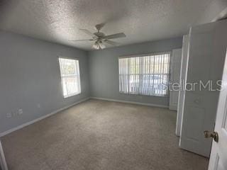 interior space with ceiling fan, carpet floors, and a textured ceiling