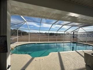 view of swimming pool with a lanai and a patio area