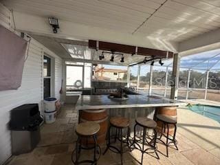 view of patio / terrace with a lanai and an outdoor bar