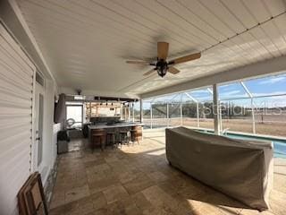 view of patio featuring exterior bar and ceiling fan