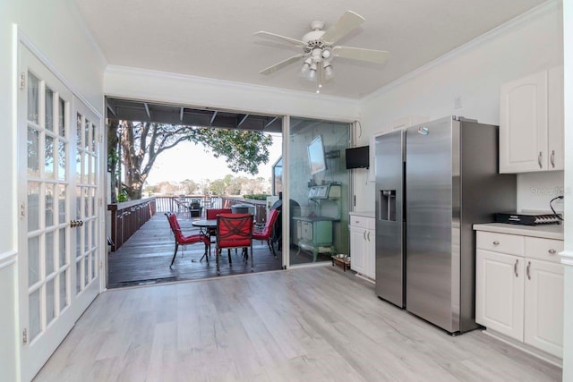 kitchen with white cabinetry, crown molding, ceiling fan, stainless steel refrigerator with ice dispenser, and light wood-type flooring