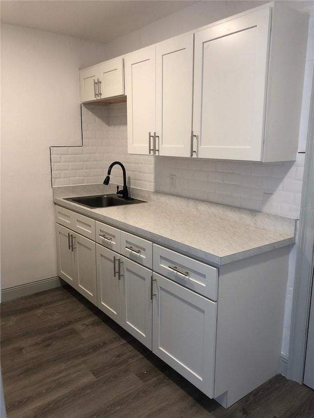 kitchen with white cabinetry, sink, backsplash, and dark hardwood / wood-style flooring