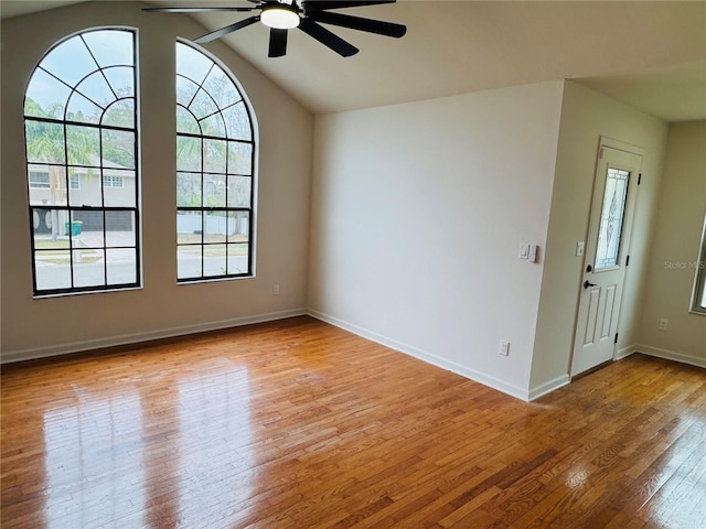 empty room with ceiling fan, lofted ceiling, and light hardwood / wood-style flooring