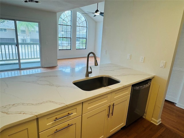 kitchen featuring sink, light stone countertops, dark hardwood / wood-style floors, and black dishwasher