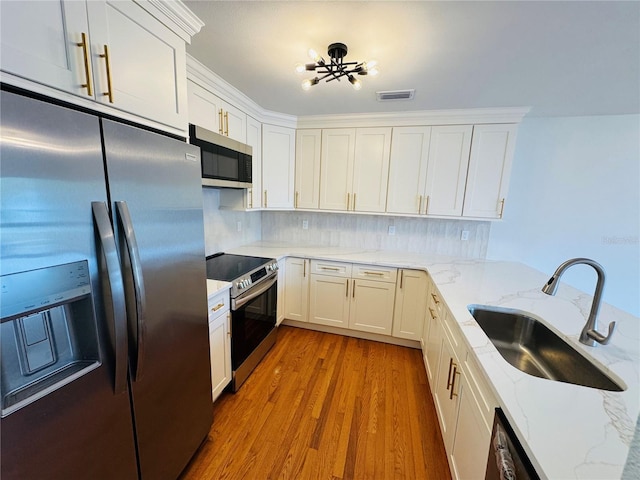 kitchen with appliances with stainless steel finishes, sink, and white cabinets