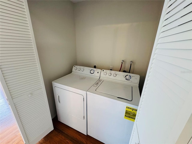 clothes washing area with dark hardwood / wood-style floors and washer and clothes dryer