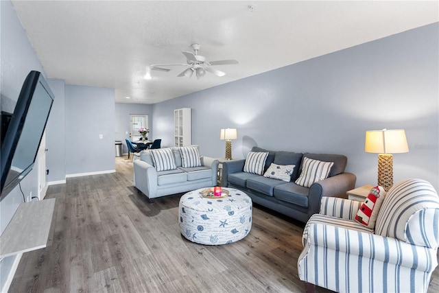 living room featuring hardwood / wood-style floors and ceiling fan