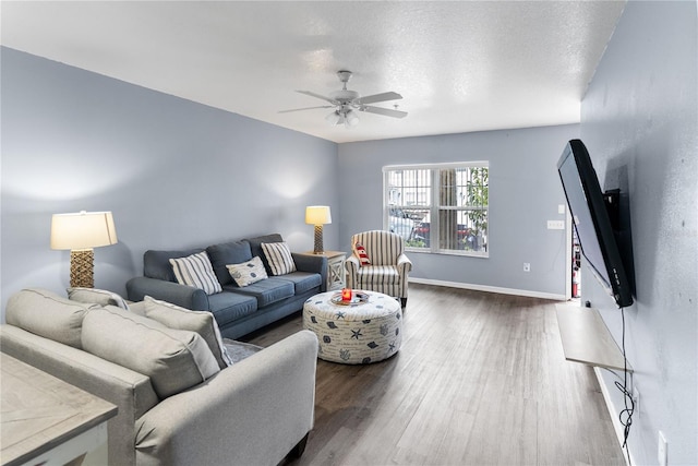 living room with dark wood-type flooring, a textured ceiling, and ceiling fan