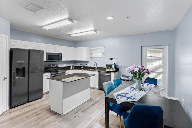 kitchen with white cabinetry, appliances with stainless steel finishes, sink, and a kitchen island