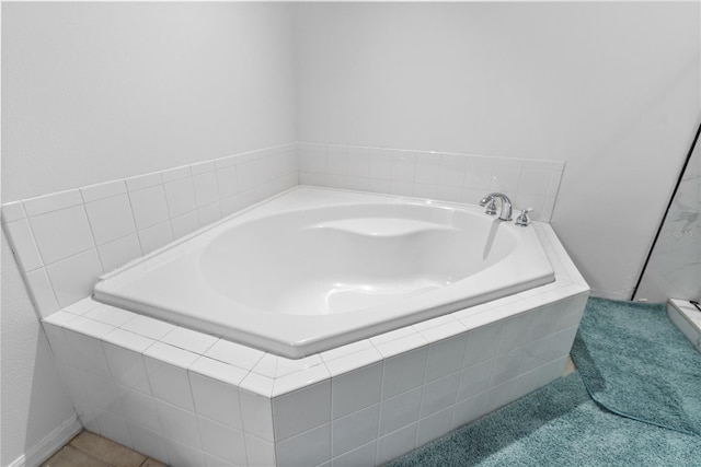 bathroom featuring tile patterned floors and tiled bath