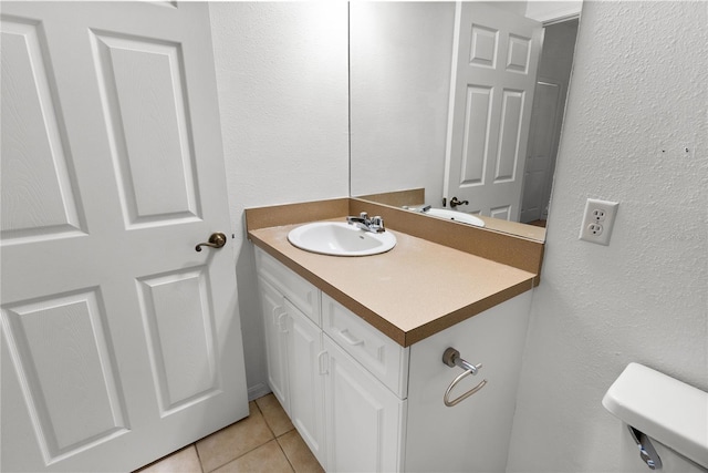 bathroom with tile patterned flooring, vanity, and toilet