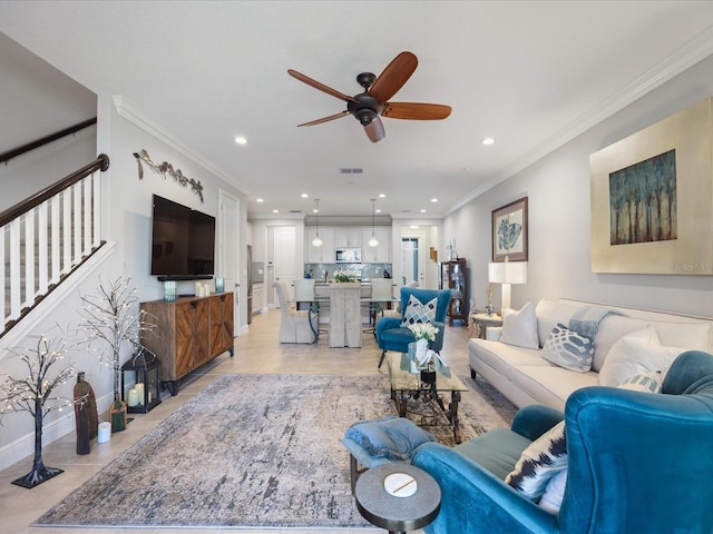 tiled living room with ornamental molding and ceiling fan