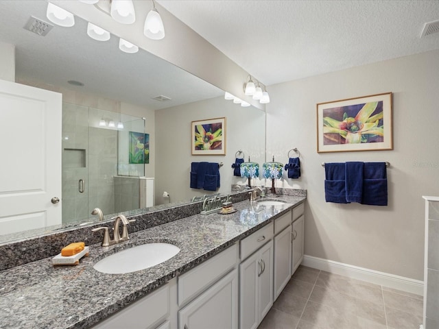 bathroom with vanity, tile patterned floors, a textured ceiling, and walk in shower