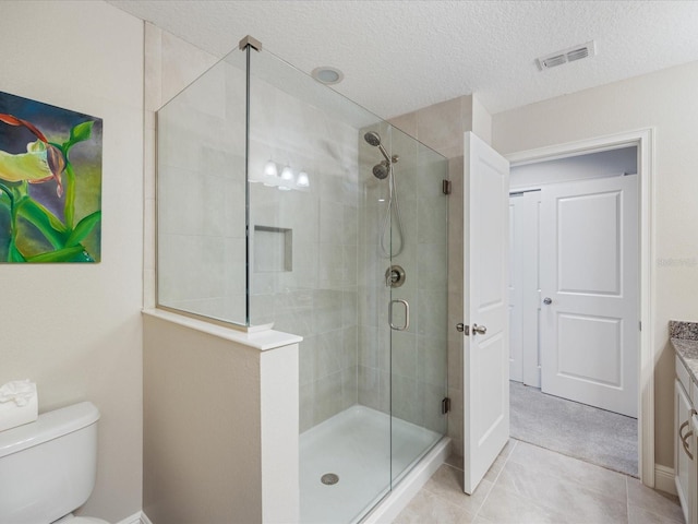 bathroom with tile patterned floors, toilet, an enclosed shower, a textured ceiling, and vanity