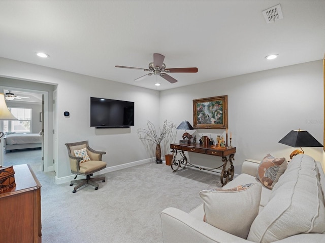 carpeted living room with ceiling fan