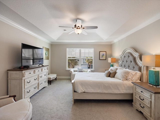 carpeted bedroom featuring ceiling fan, ornamental molding, a tray ceiling, and a textured ceiling