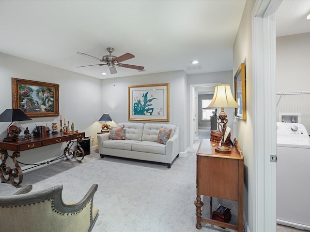 living room featuring light carpet, washer / dryer, and ceiling fan