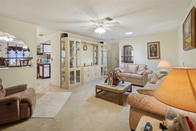 carpeted living room with ceiling fan and a textured ceiling