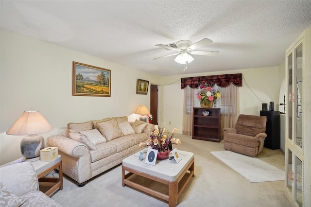 carpeted living room with ceiling fan and a textured ceiling