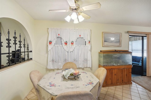 dining room with ceiling fan, a textured ceiling, and light tile patterned floors