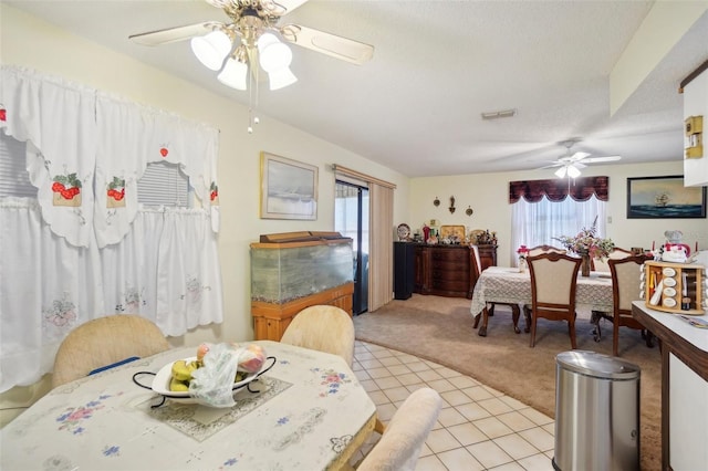 carpeted dining space with ceiling fan, a wealth of natural light, and a textured ceiling