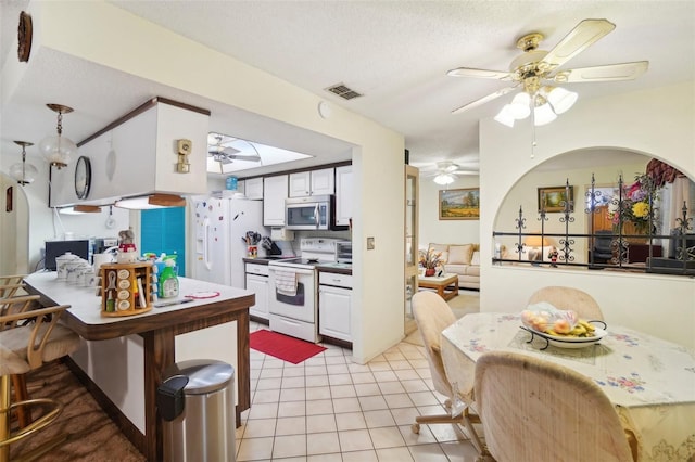 kitchen featuring white cabinets, light tile patterned floors, white appliances, ceiling fan, and a textured ceiling