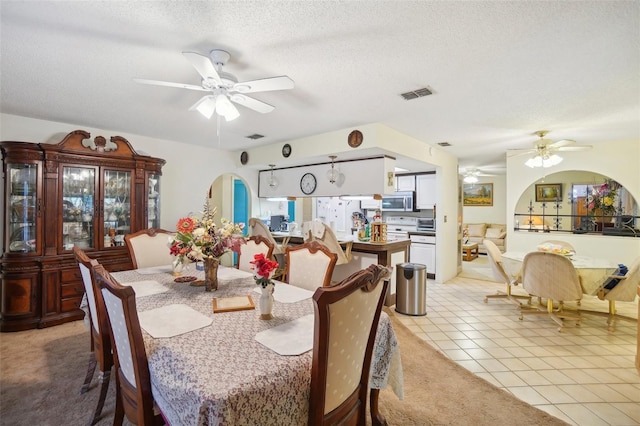 dining area with light tile patterned floors, a textured ceiling, and ceiling fan