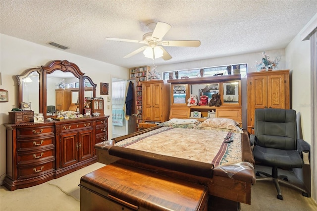 bedroom featuring ceiling fan, light colored carpet, and a textured ceiling