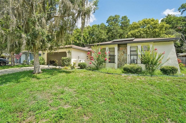 ranch-style house with a garage, a front lawn, and solar panels