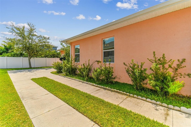 view of home's exterior with a patio area and a lawn