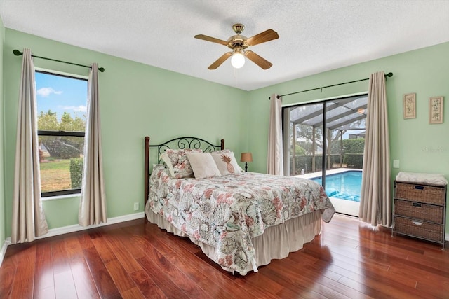 bedroom featuring multiple windows, dark wood-type flooring, and access to exterior