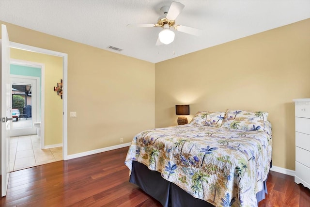 bedroom with ceiling fan, wood-type flooring, and a textured ceiling